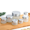 wholesale 10g 20g 30g 50g 100g sustainable transparent glass cosmetic jars frosted with silver lids