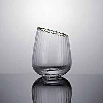 Slanted tumbler glass with gold rim