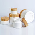 Jarra de crema blanca para el cuidado de la piel de plástico con tapa de bambú